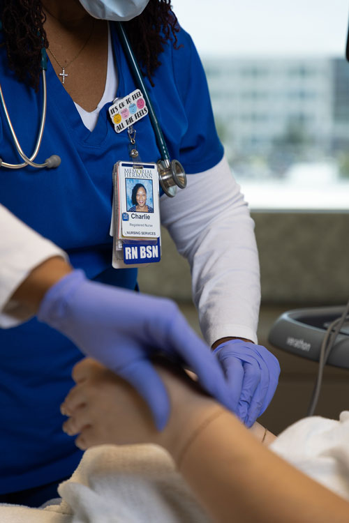 image of nurse checking a patient and only her badge is visible