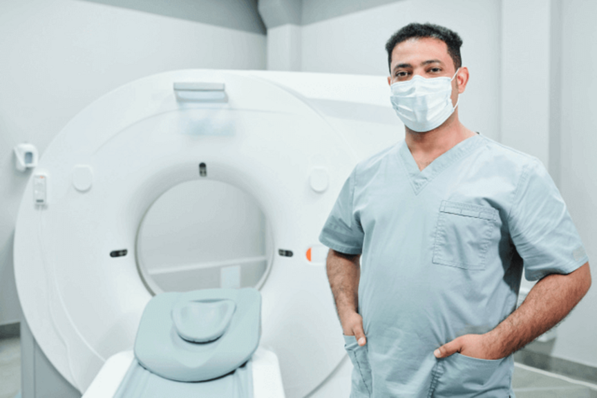 Tech in front of CT Machine
