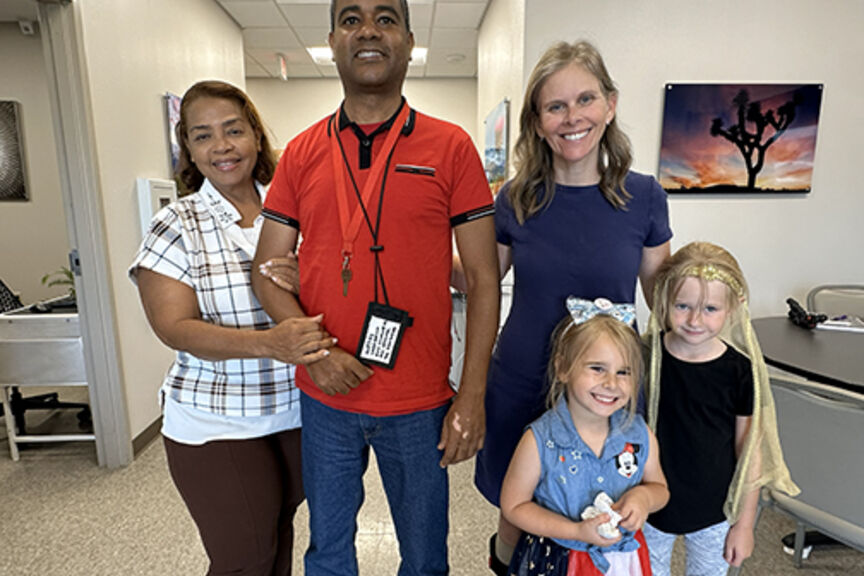 Glexey Caraballo stands with his mother, and Cathy Garrett stands with her daughters. Both Glexey and Cathy performed in STROKESTRA as part of their recovery.