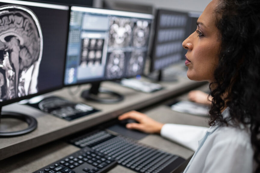 A female imaging specialist reviews a scan on a computer