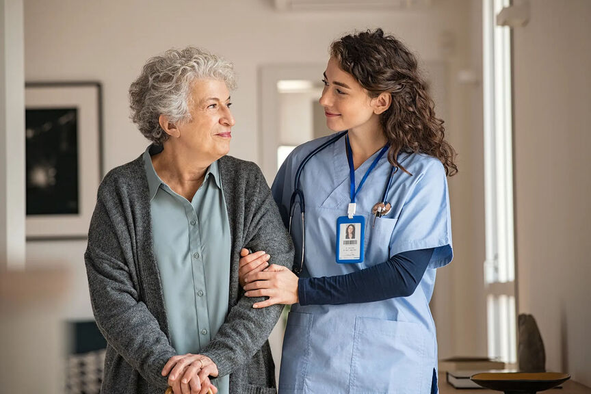 A health care worker assists and elderly patient