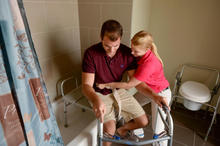An occupational therapy student providing bathroom assistance.