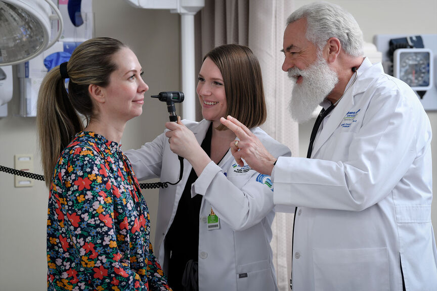 A student examines a patient under faculty supervision