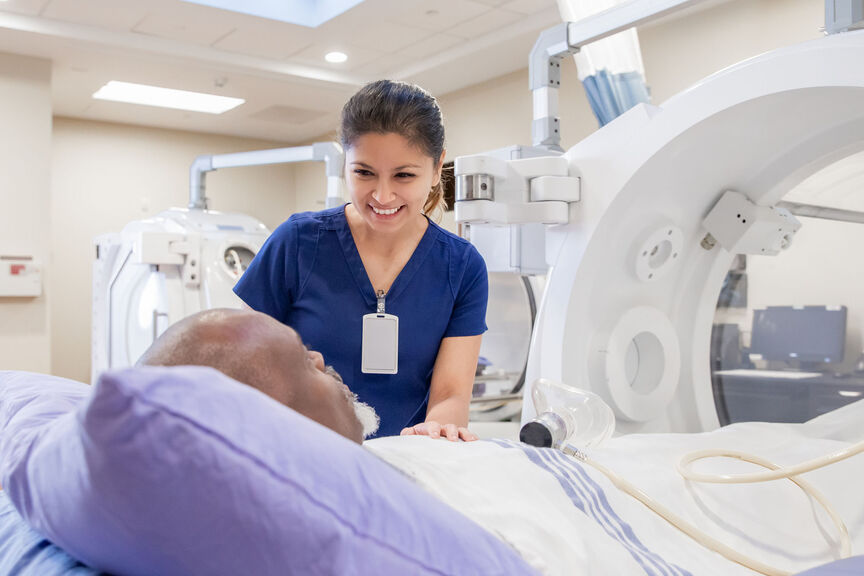 An imaging tech assuring a patient before a scan