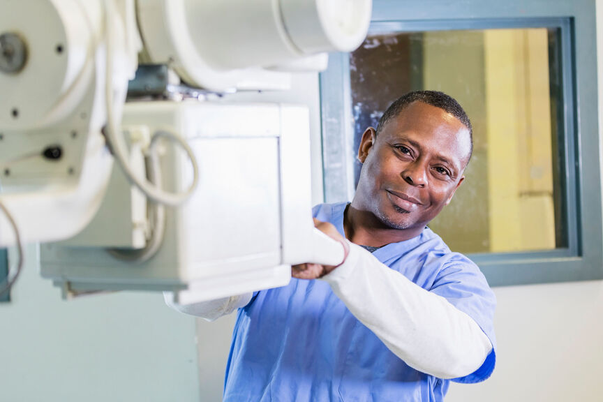 A male radiologic technologist getting ready to perform a scan.