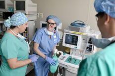 A faculty member demonstrates equipment use in the skills lab