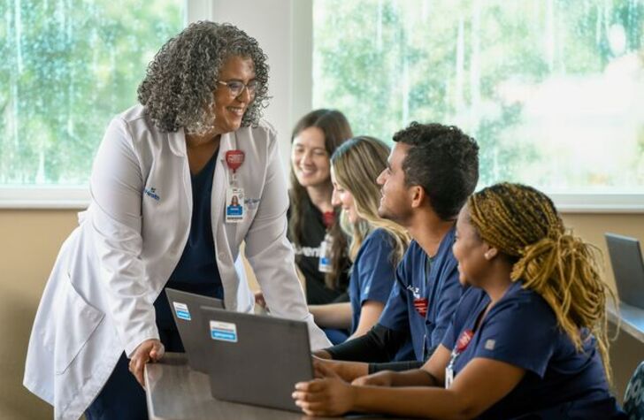 nursing students smiling at teacher in classroom