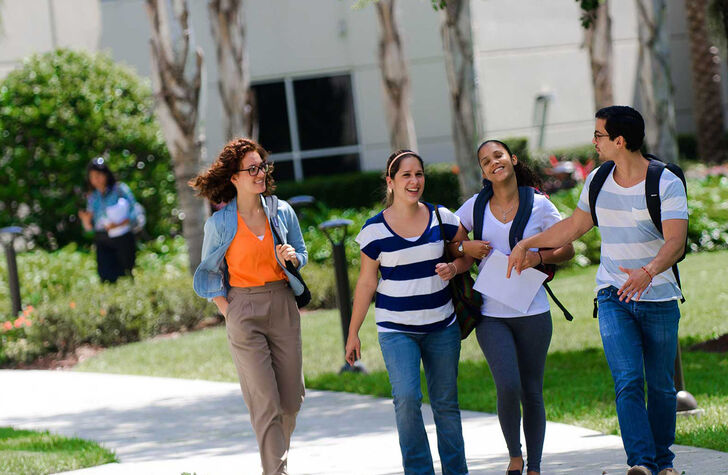 A group of students walks outside on campus