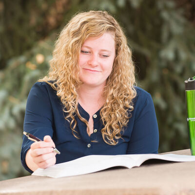 A female student studying outdoors at a picnic table