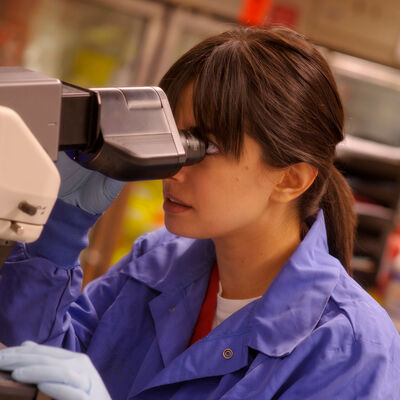 A young female student uses a microscope