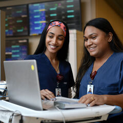 Young nurses viewing a computer on a mobile workstation
