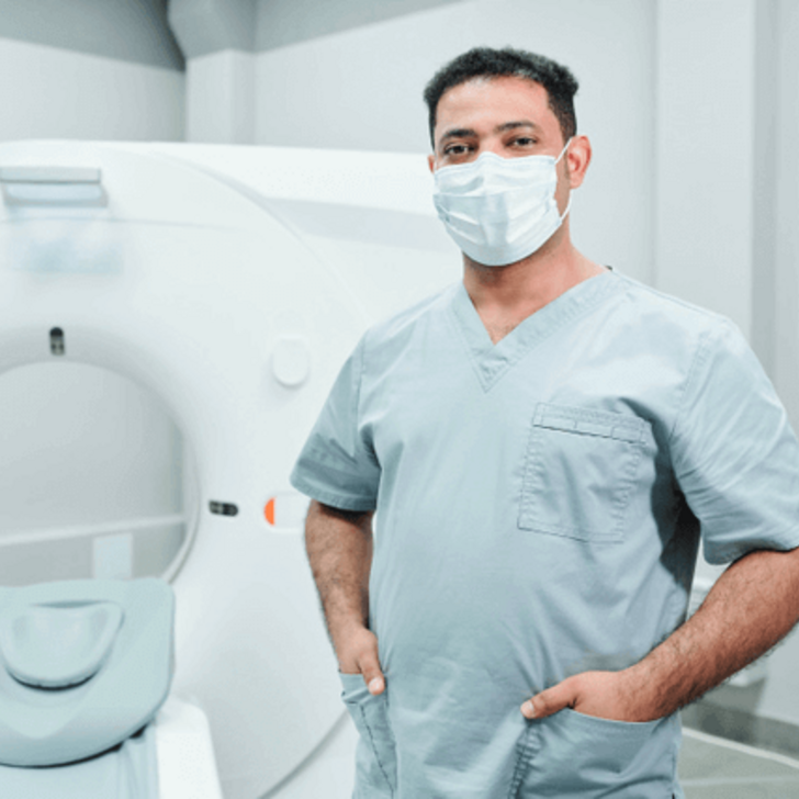 Tech in front of CT Machine