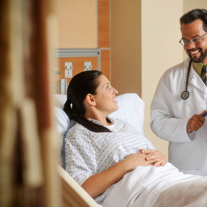 Doctor talking with patient in hospital bed