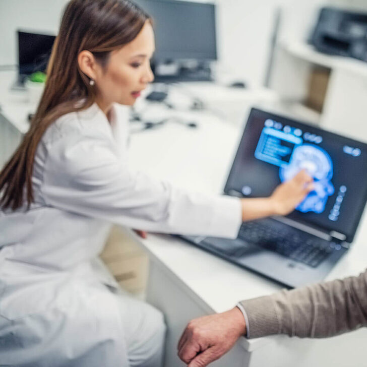 Female-doctor-showing-brain-scan-to-patient