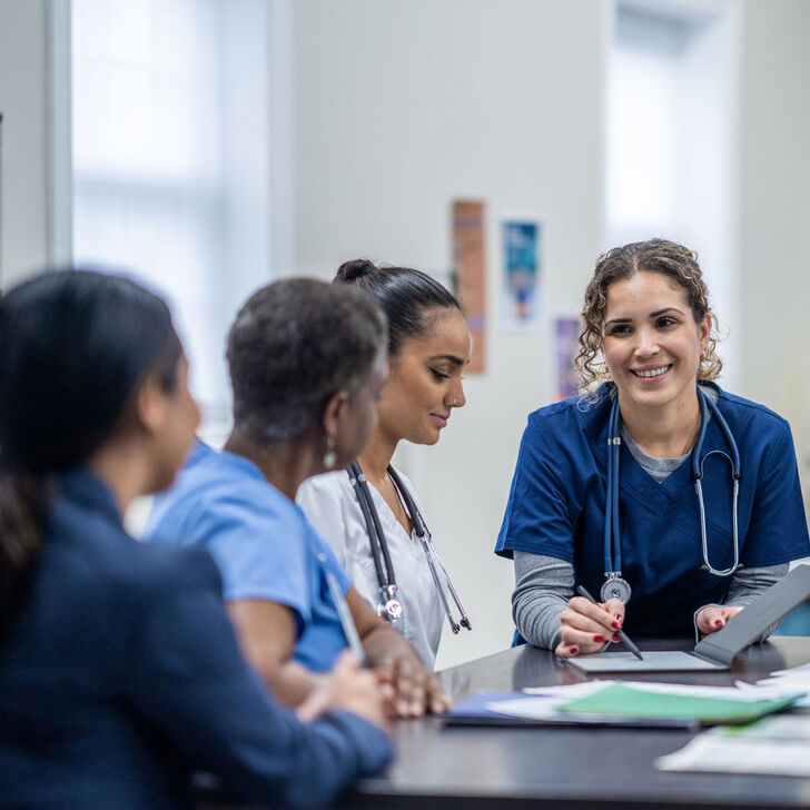A female nurse supervisor meets with her team