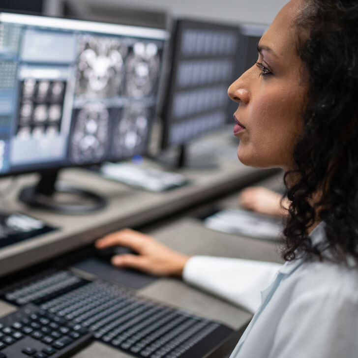 A female imaging specialist reviews a scan on a computer