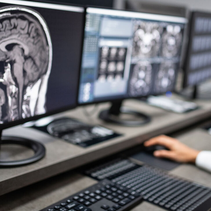 A female imaging specialist reviews a scan on a computer
