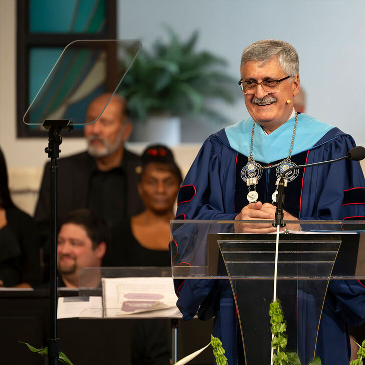 Josef Ghosn in regalia speaking at the lectern during the inauguration ceremony