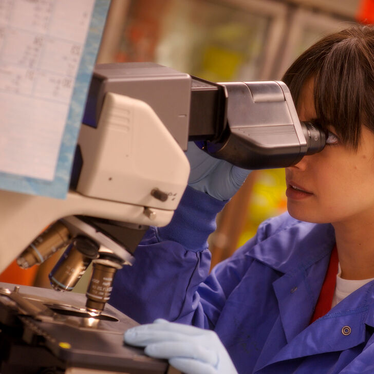 A young female student uses a microscope