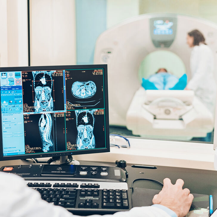 A Patient Receives a MRI Scan While a Radiologist and Nurse Look After Their Care