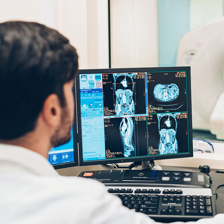 A Patient Receives a MRI Scan While a Radiologist and Nurse Look After Their Care