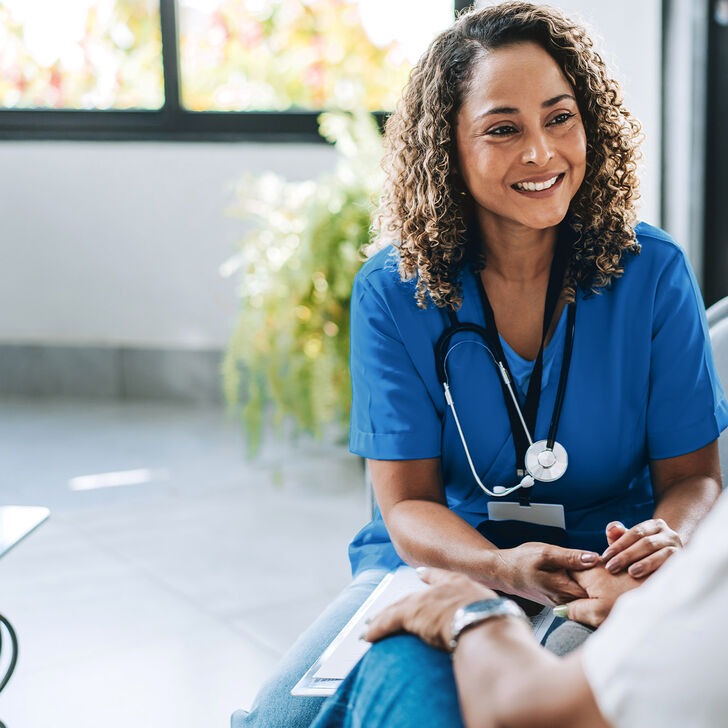 A nurse practitioner converses with a patient