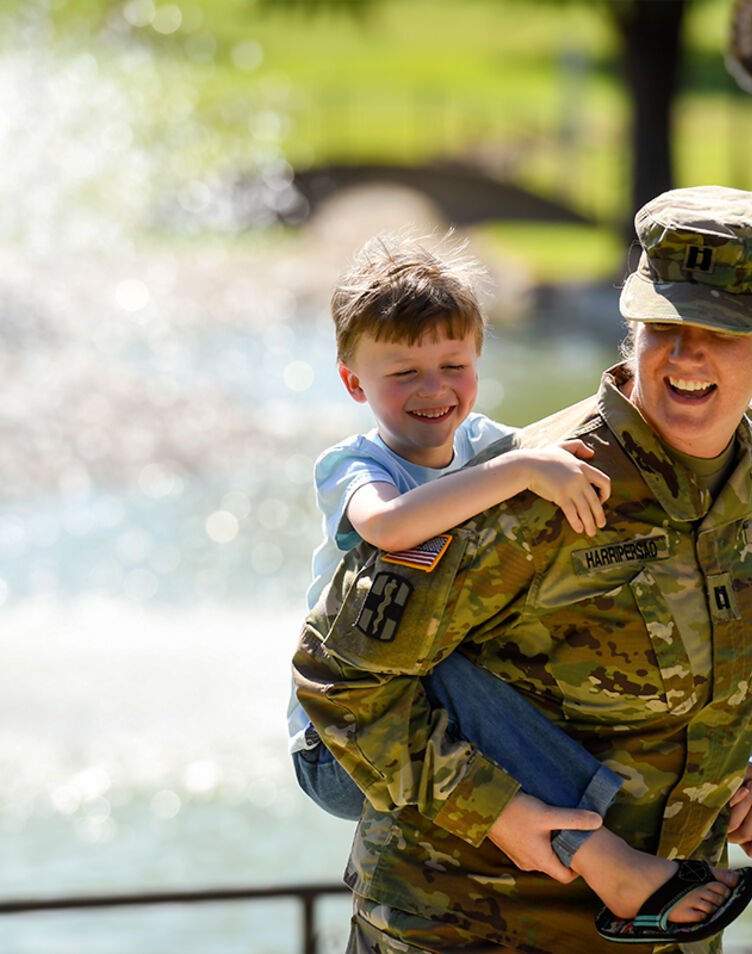 Military mom in uniform sitting with her kids in the park